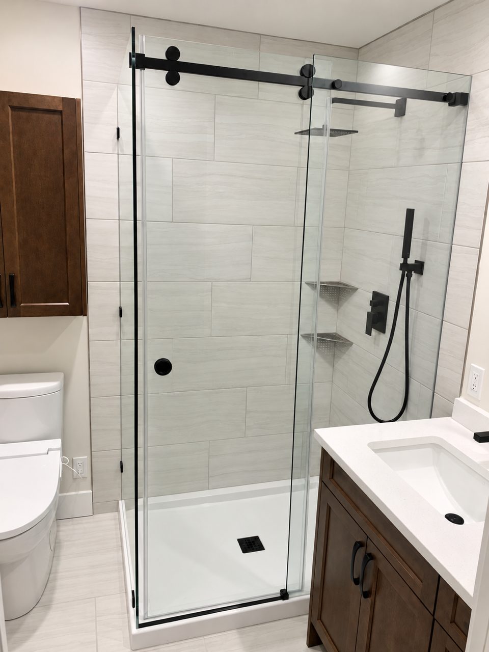 Glass walk-in shower with black hardware in the enlarged ensuite